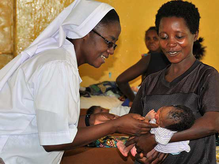 Picture of a Nyakasanza Nun Giving a Medical to a New Born baby